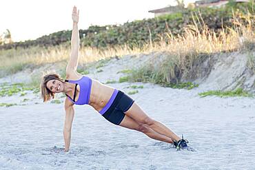 Caucasian woman working out on beach