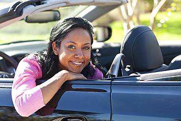 Indian woman smiling in convertible