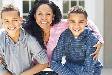 Close up of mother hugging sons outdoors