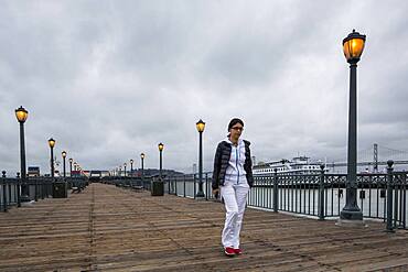 Middle Eastern woman walking on pier