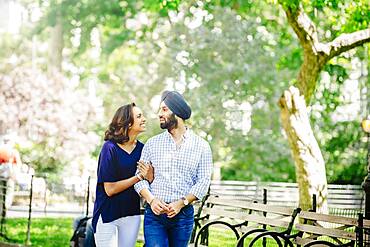 Indian couple walking in urban park