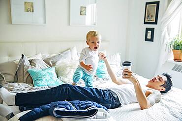 Father and son playing on bed