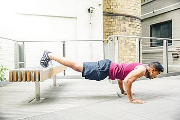 Indian man doing push-ups on bench