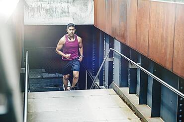 Indian man jogging on city steps