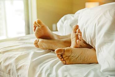 Close up of feet of couple in bed