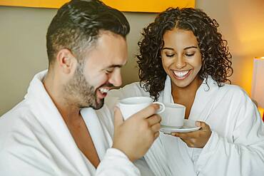 Couple drinking coffee in hotel room