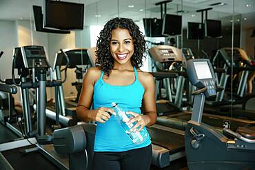 Woman smiling near exercise machines in gymnasium