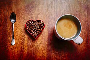 Spoon, beans and cup of coffee on counter