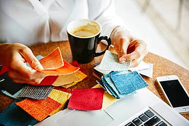 Mixed race designer examining fabric swatches