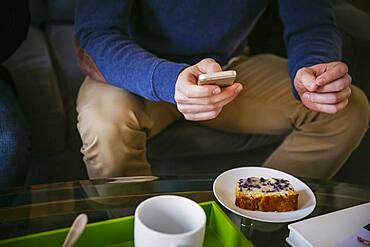 Caucasian man using cell phone at breakfast