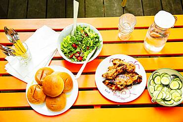 High angle view of salad, meat, cucumbers and salad on table