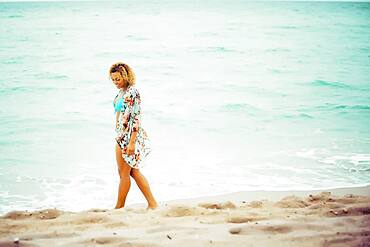 Mixed race teenager wearing cover-up on beach