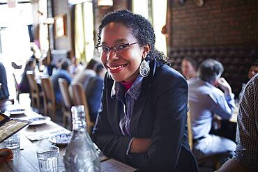 Black woman sitting at restaurant table