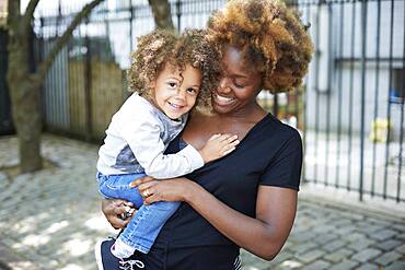 Mother holding daughter outdoors