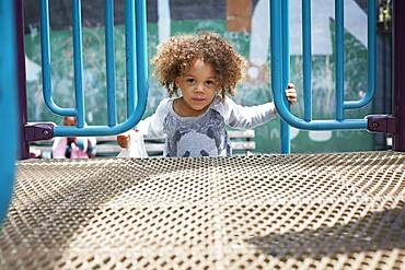 Mixed race boy climbing on play structure