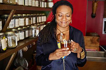 Black woman drinking tea in tea shop