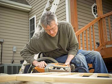 Caucasian paraplegic man wood working in backyard