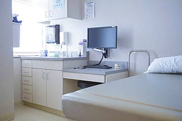 Empty bed and television in hospital room