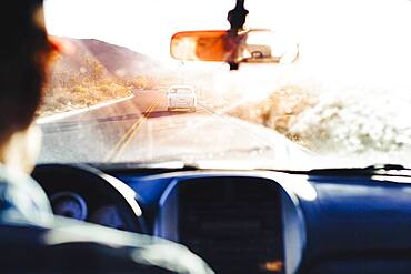 Caucasian man driving car on remote road