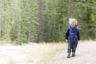 Caucasian boy hiking in forest