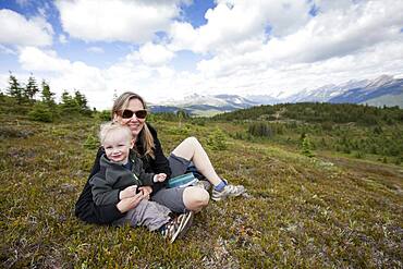 Caucasian mother and son sitting on remote hilltop