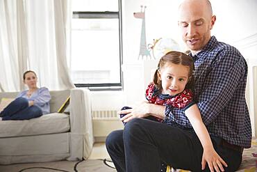 Father and daughter sitting on bed