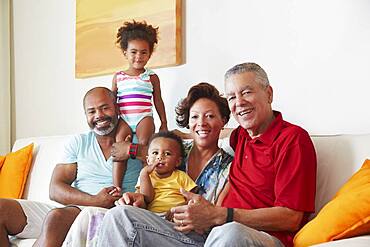 Multi-generation family smiling on sofa