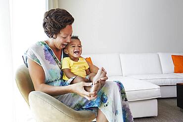 Black mother and son sitting in living room