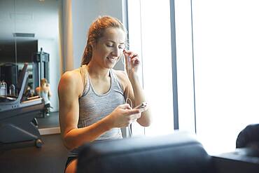 Woman listening to mp3 player in gym