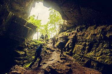 Hikers exploring rock cave