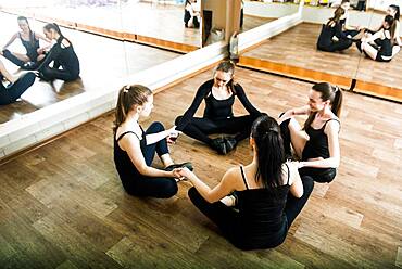 Caucasian dancers stretching in studio