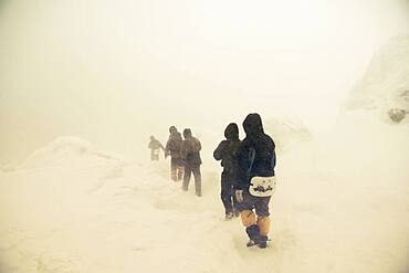 Caucasian hikers walking on snowy path