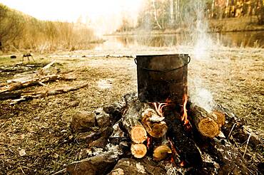 Pot cooking on campfire in rural field