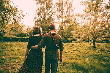 Caucasian couple walking in field