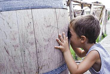 Caucasian boy peering into barrel