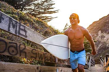 Caucasian surfer carrying surfboard