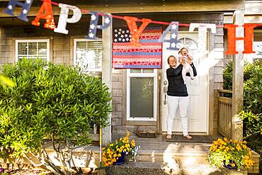 Caucasian mother and baby daughter celebrating 4th of July