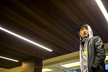 Asian man walking under wooden ceiling