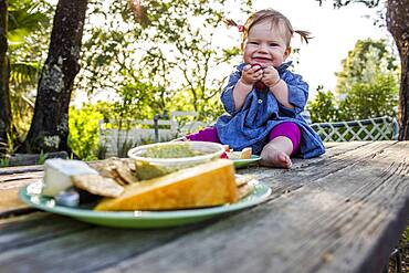 Caucasian baby girl sitting on patio table