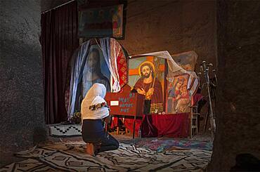 Black woman praying at shrine