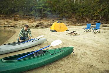 Man pushing kayak into lake