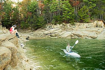 Woman watching boyfriend in kayak in lake