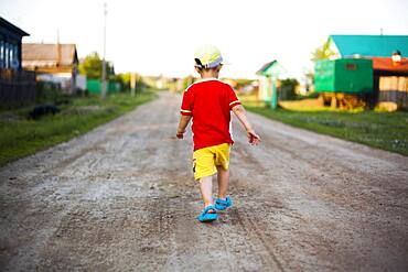 Mari boy walking on dirt path