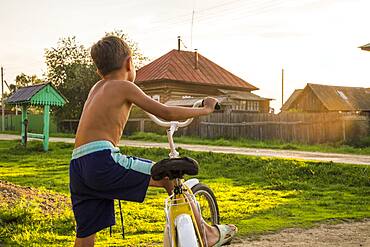 Mari boy riding bicycle