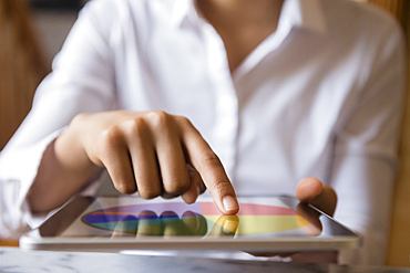 Finger of African American woman using digital tablet