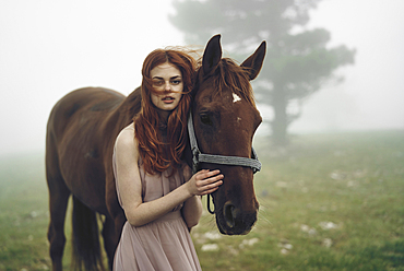 Caucasian woman petting horse