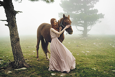 Caucasian woman petting horse