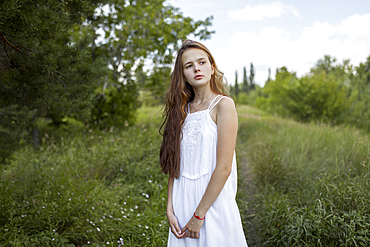 Pensive Caucasian girl standing in field