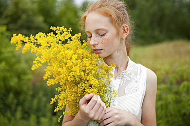 Caucasian girl smelling wildflowers