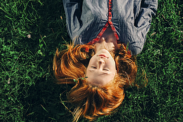 Caucasian teenage girl laying in grass